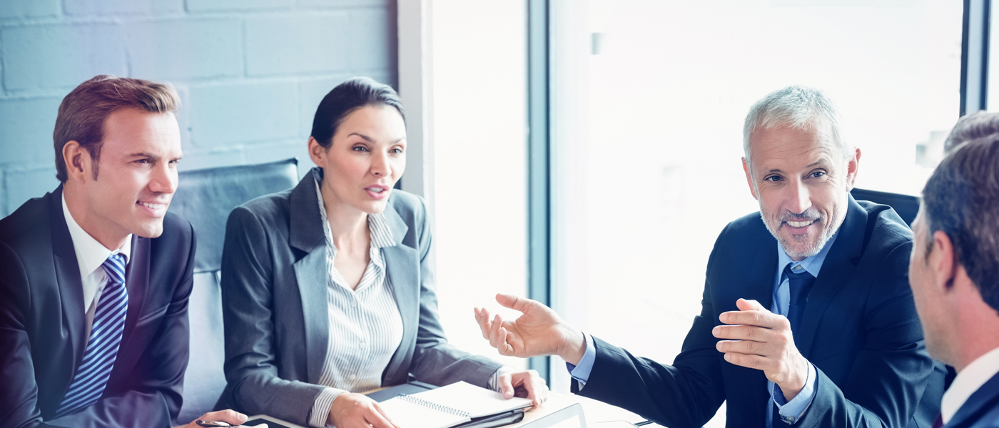 Group of business professionals engaged in a discussion during a corporate meeting.