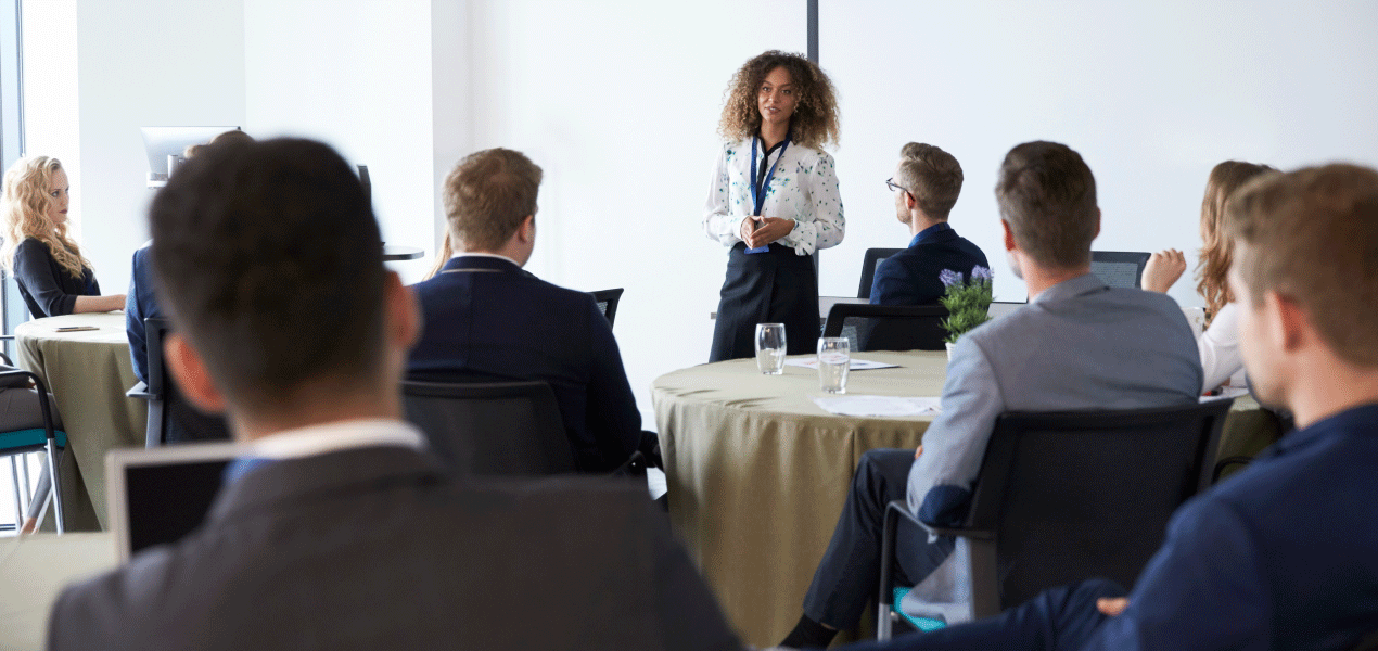 Attendees seated in a large conference hall listening to a panel discussion during the Ontario Legal Conference, with speakers on stage and a presentation screen visible.