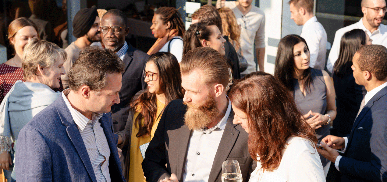 Professionals networking and conversing at a business event.