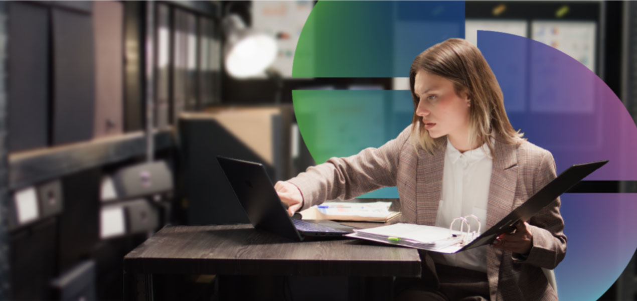 Woman working on a laptop at a desk in a modern office.