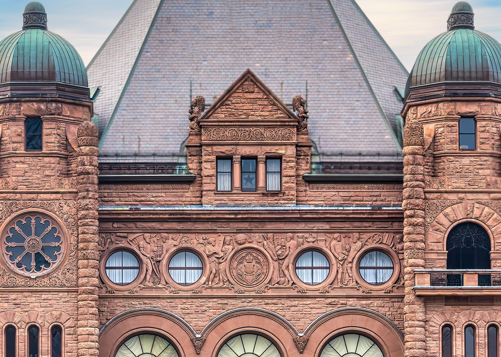 A building with brown brick, two columns either side