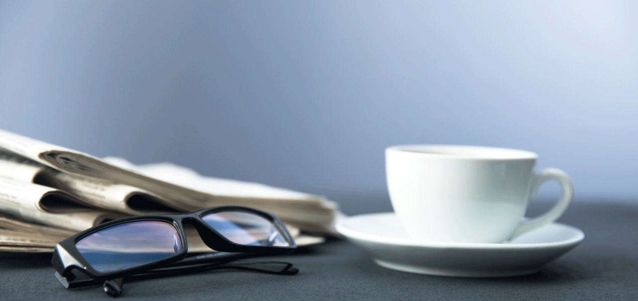 Eyeglasses and coffee on a desk during a work break