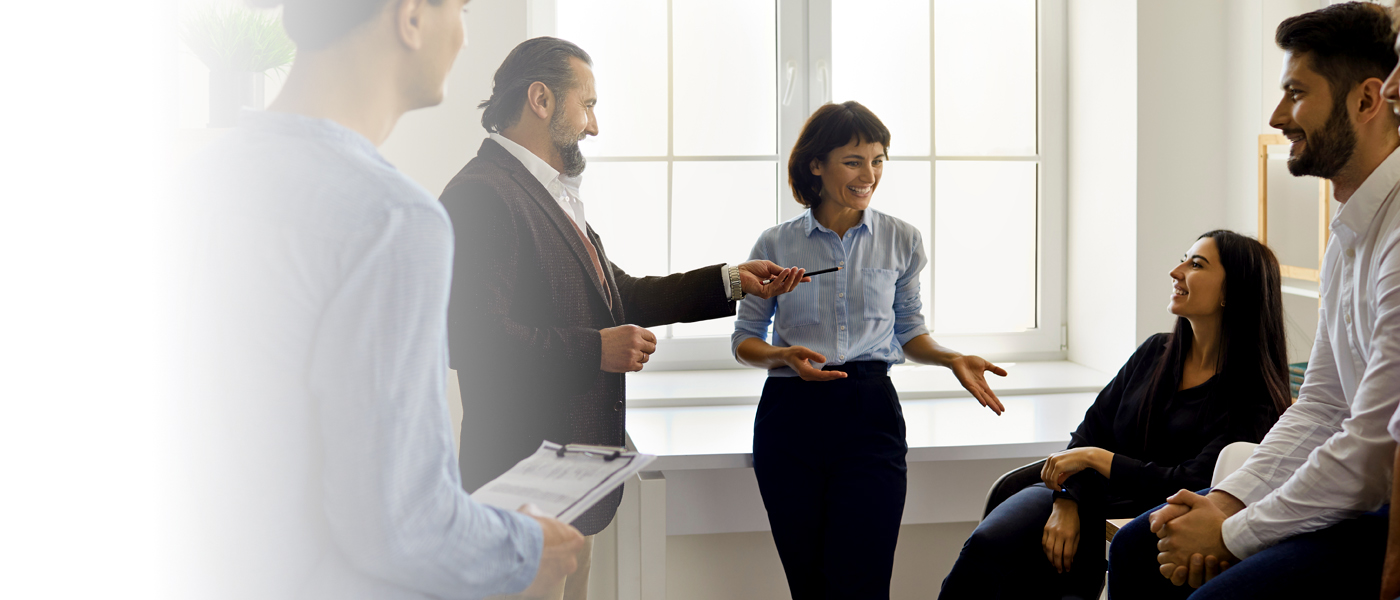 Group of professionals engaged in a discussion in a bright office setting.