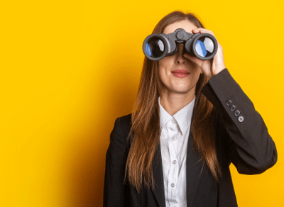 Young woman wearing a virtual reality headset and holding binocular-style VR goggles against a bright yellow background, representing immersive technology and innovation.
