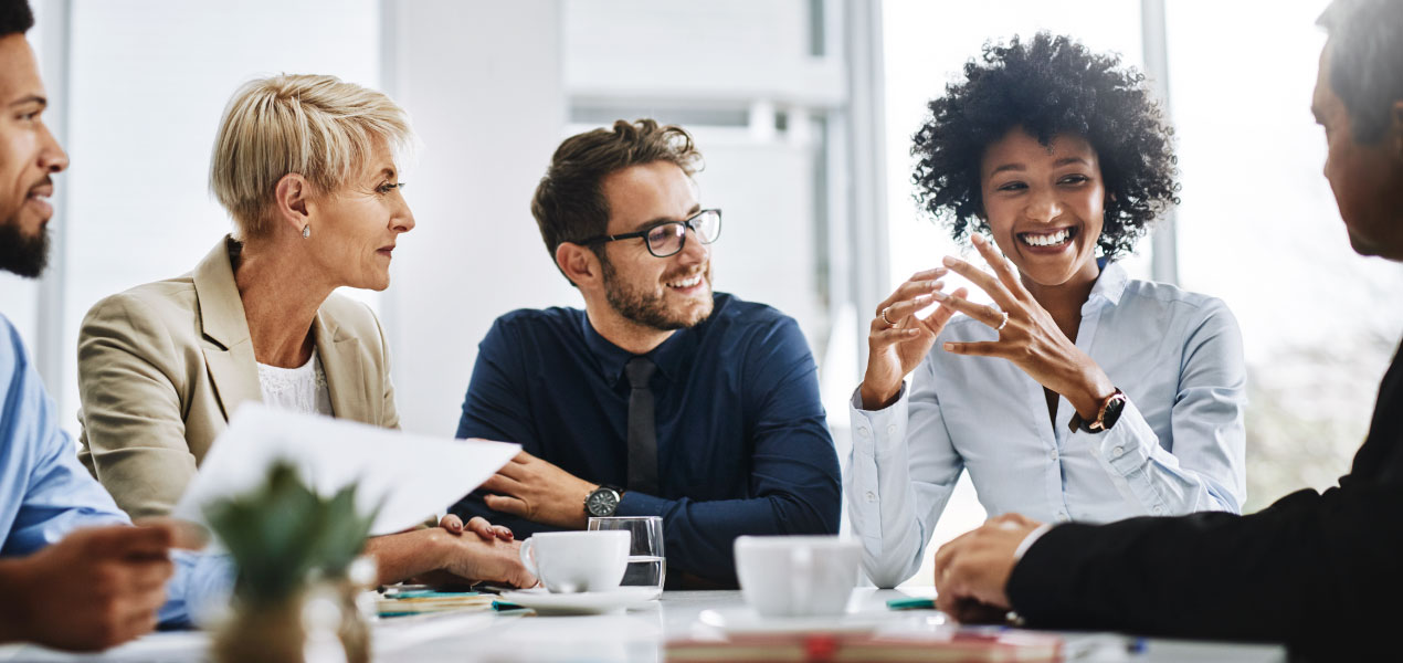 Diverse group of professionals engaged in a lively discussion during a business meeting.