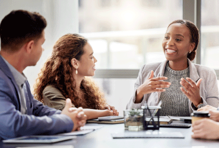 Diverse group of young professionals collaborating around a table in a modern office.