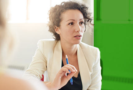 Professional woman in a business meeting, attentively listening and holding a pen.