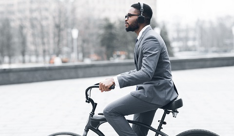 Man communiting to work on a bike wearing headphones