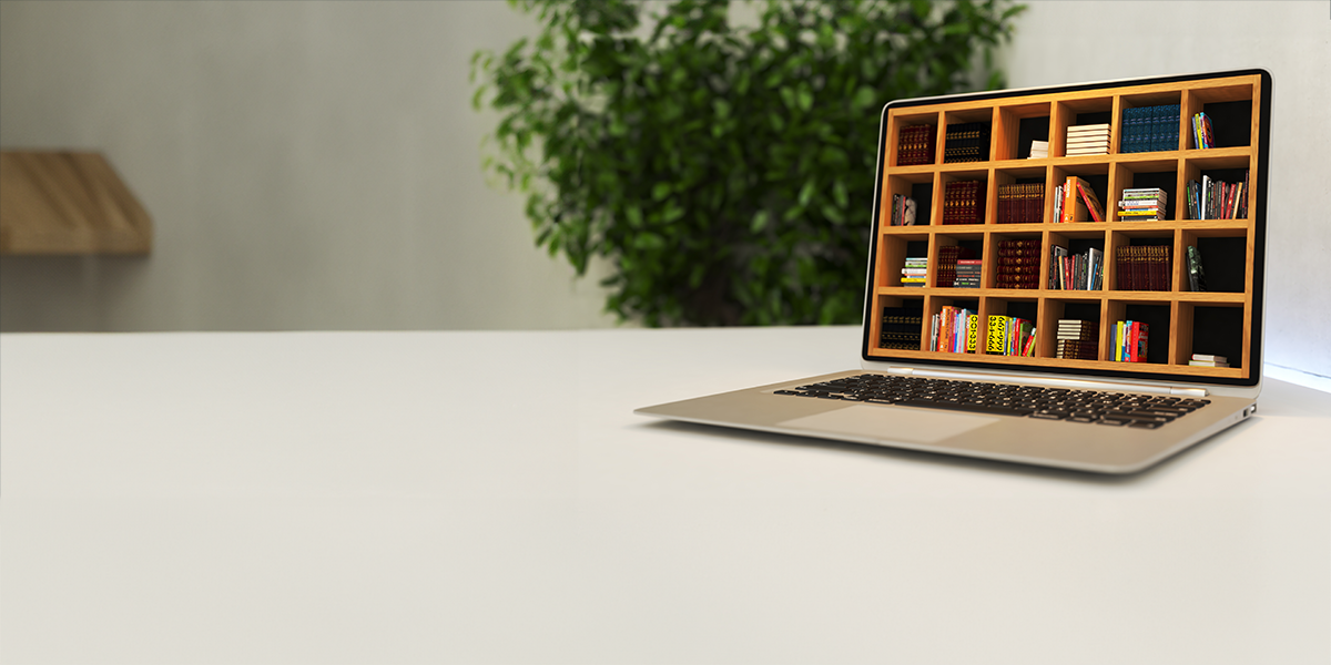 A laptop on a white desk with its screen displaying a wooden bookshelf filled with books, symbolizing digital learning or online library access.