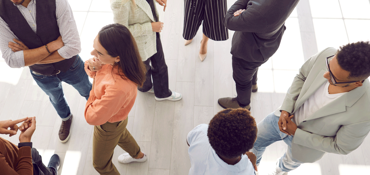 Overhead view of diverse professionals networking and shaking hands at a business event.
