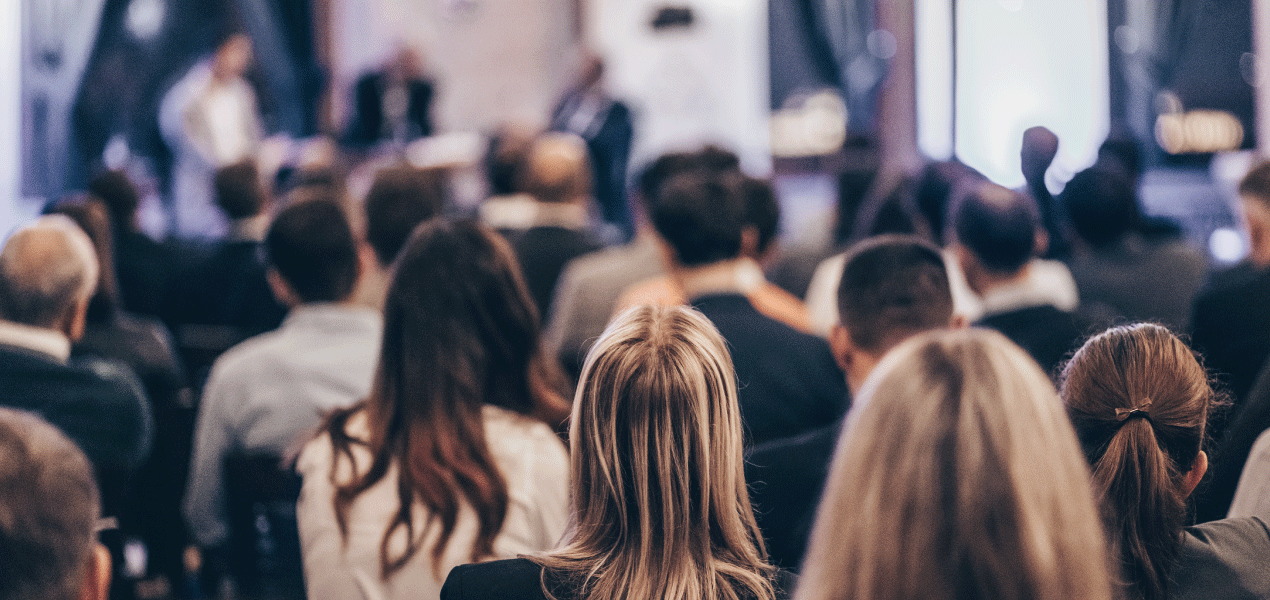 Attendees seated in a modern conference room listening to a speaker during a professional presentation at the Annual OLC Conference.