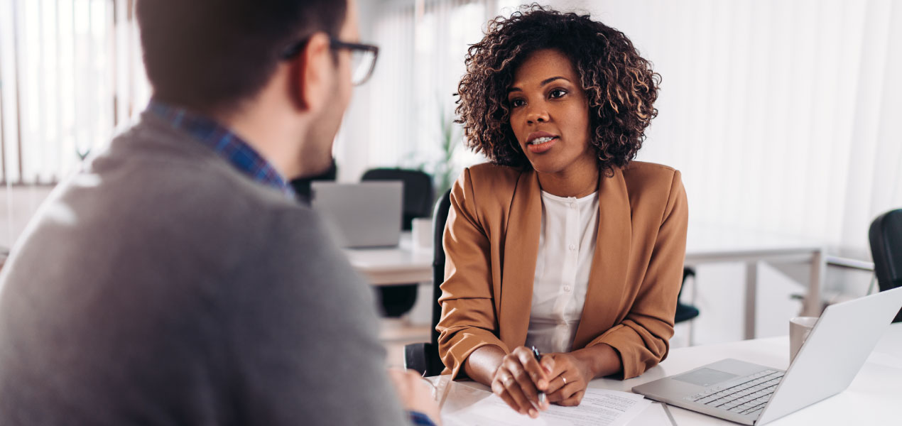 Professional woman attentively listening during a business meeting in a modern office setting.