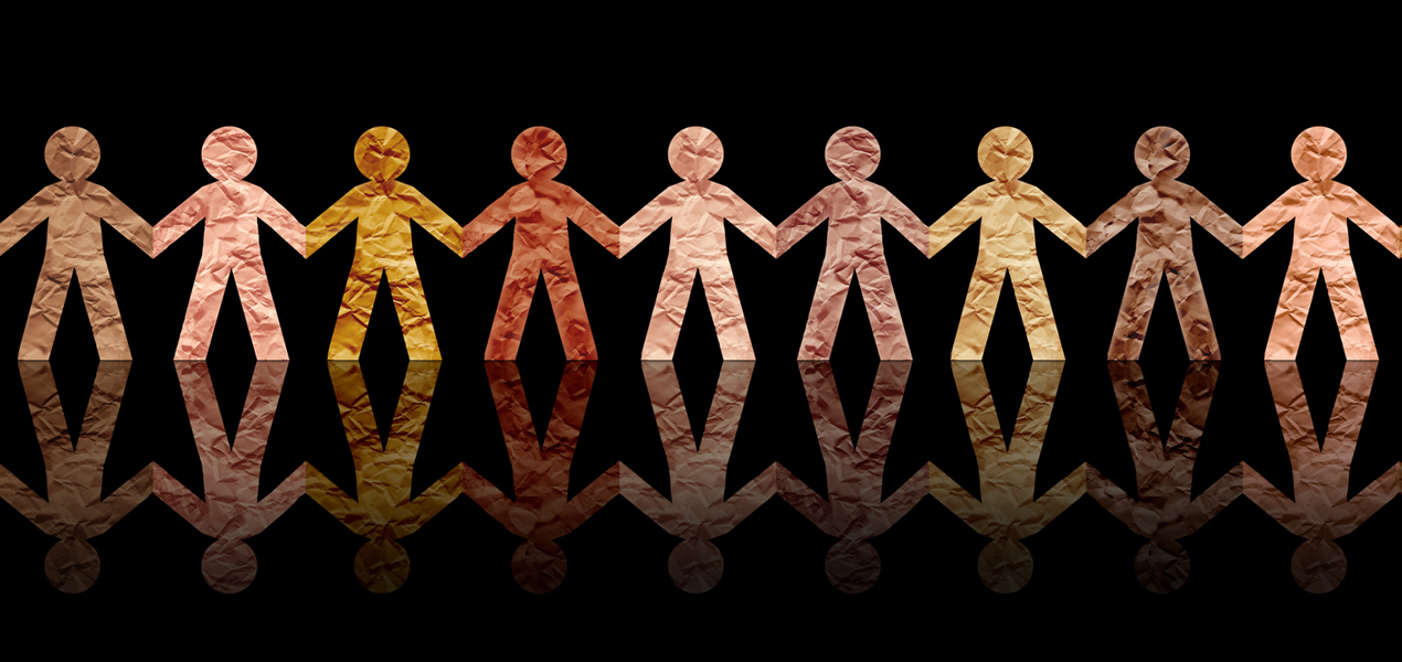 A chain of paper dolls of various skins tones holding hands.