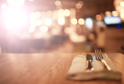 Table set with cutlery inside a warmly lit bar