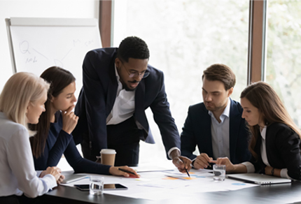 "Colleagues in a business meeting gathered around a table for a briefing.