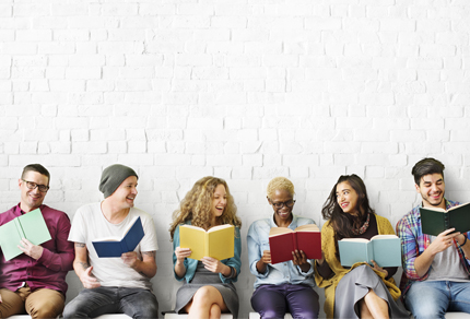 Group of people sitting in a row reading books